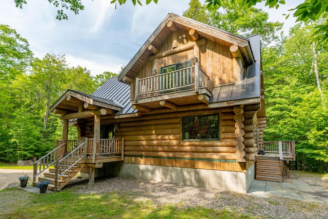320 Commons Dr, Bridgton, ME 04009 - log-style house featuring log siding, a metal roof, a standing seam roof, a balcony, and stairs