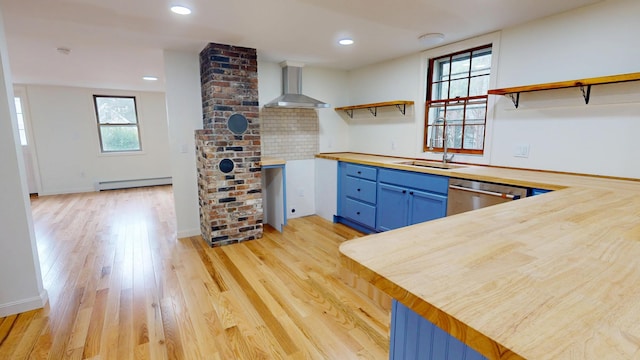 14 Pond St, Orono, ME 04473 - kitchen with open shelves, wall chimney exhaust hood, baseboard heating, blue cabinets, and stainless steel dishwasher