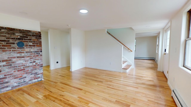 14 Pond St, Orono, ME 04473 - unfurnished room featuring a baseboard radiator, stairs, light wood-style floors, a baseboard heating unit, and plenty of natural light