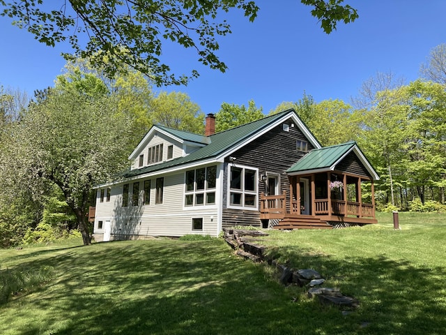 124 Gray Rd, Sangerville, ME 04479 - rear view of property featuring a chimney, a yard, a deck, and a metal roof