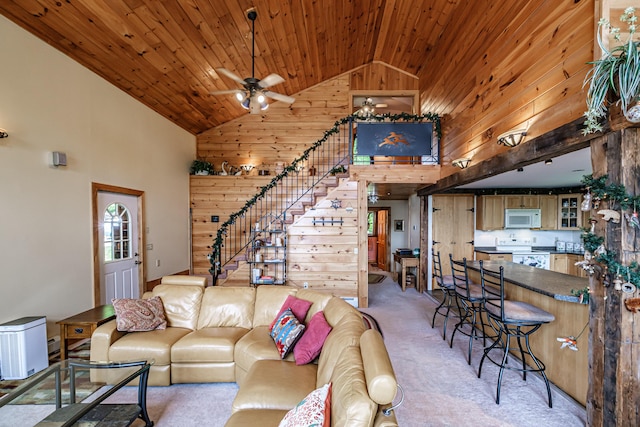 309A Cushman Rd, Woodstock, ME 04219 - living area with high vaulted ceiling, stairway, wooden walls, light colored carpet, and a ceiling fan
