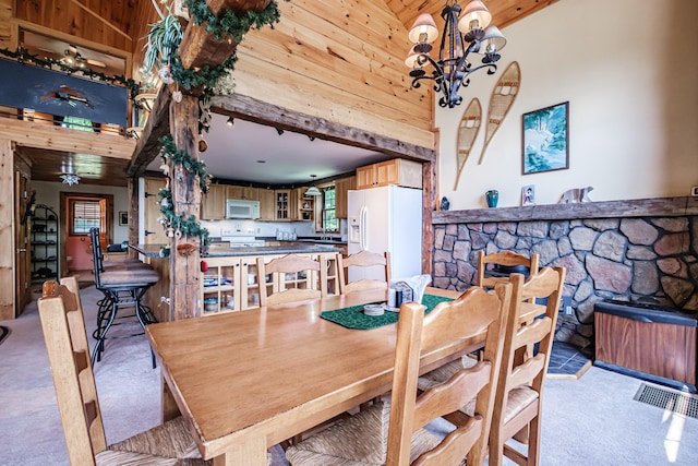 309A Cushman Rd, Woodstock, ME 04219 - dining area with light carpet, a chandelier, a towering ceiling, wood ceiling, and wooden walls