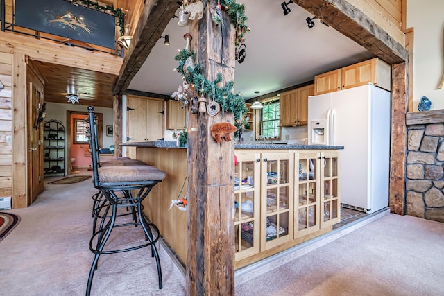 309A Cushman Rd, Woodstock, ME 04219 - kitchen with white refrigerator with ice dispenser, light colored carpet, light brown cabinets, a breakfast bar, and dark countertops