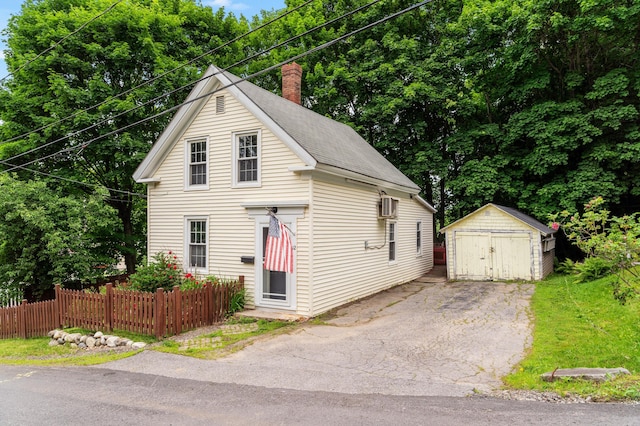 12 Robinson St, Gardiner, ME 04345 - view of front of property with a storage unit, a detached garage, a chimney, and a shingled roof