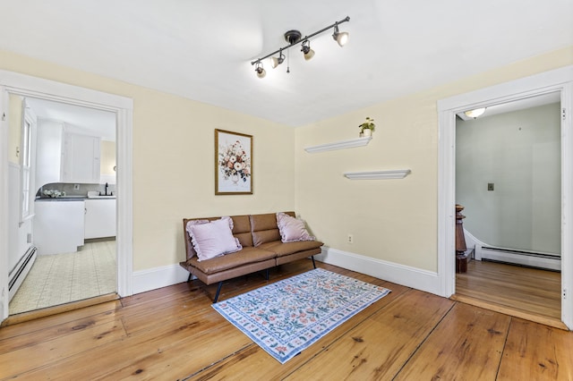 12 Robinson St, Gardiner, ME 04345 - living area with a baseboard radiator, light wood-style floors, and track lighting