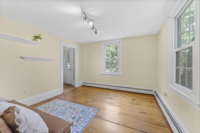 12 Robinson St, Gardiner, ME 04345 - bedroom featuring a baseboard radiator, wood-type flooring, and track lighting