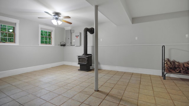 326 Meetinghouse Rd, Wells, ME 04090 - below grade area with a ceiling fan, a wood stove, and tile patterned flooring