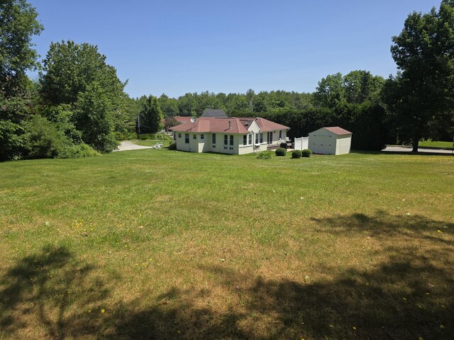 135 Hotel Rd, Auburn, ME 04210 - view of grassy yard featuring a storage unit and a wooded view