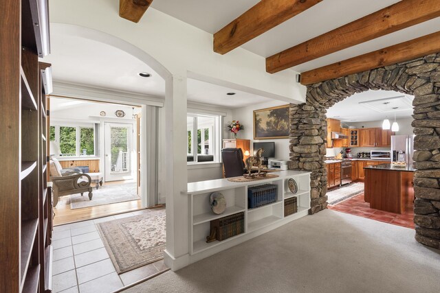 11 Everett Dow Dr, Woolwich, ME 04579 - kitchen featuring stainless steel refrigerator with ice dispenser, ornate columns, arched walkways, light tile patterned floors, and brown cabinets
