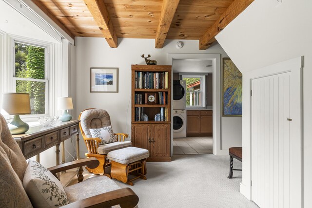 11 Everett Dow Dr, Woolwich, ME 04579 - living area featuring stacked washer / dryer, light colored carpet, and a wood ceiling with exposed beams