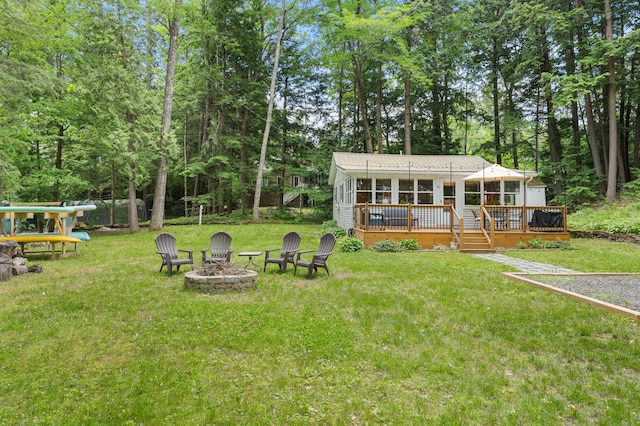 8 N Lakeview Dr, Litchfield, ME 04350 - view of grassy yard featuring an outdoor fire pit, a wooden deck, and a sunroom