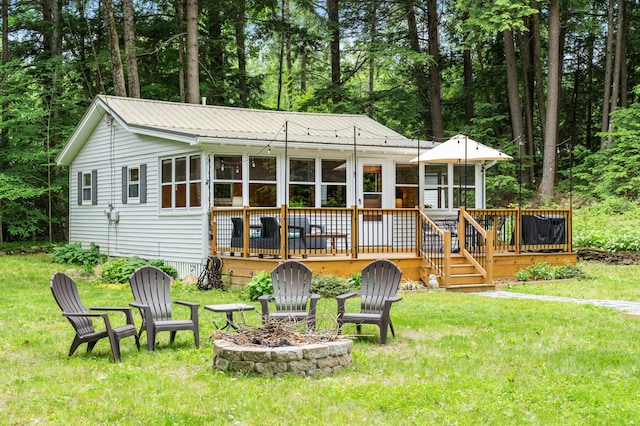 8 N Lakeview Dr, Litchfield, ME 04350 - back of property featuring an outdoor fire pit, a deck, and a lawn