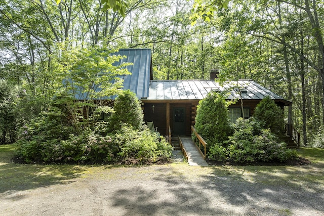 19 Fox Ln, Bremen, ME 04551 - view of front of house featuring a standing seam roof, a chimney, a metal roof, log siding, and a porch
