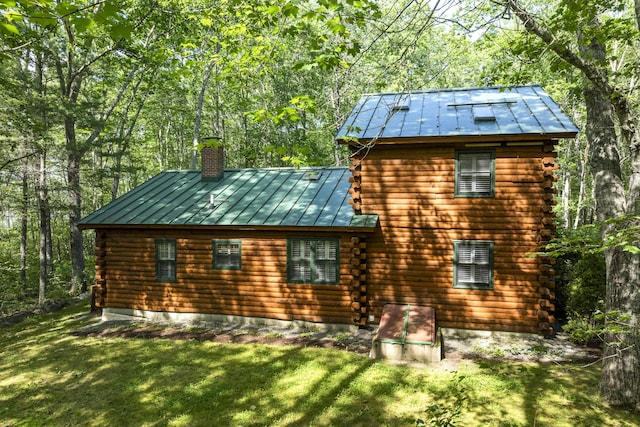 19 Fox Ln, Bremen, ME 04551 - view of home's exterior with log exterior, a standing seam roof, a chimney, and a yard