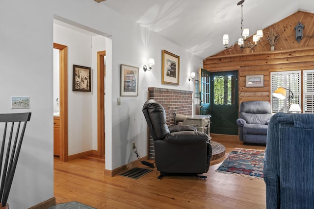 19 Fox Ln, Bremen, ME 04551 - living room featuring rustic walls, light wood finished floors, vaulted ceiling, and a chandelier