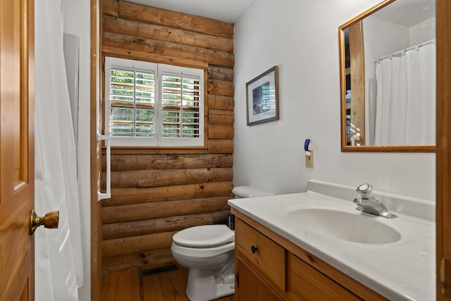 19 Fox Ln, Bremen, ME 04551 - bathroom featuring log walls, vanity, and wood finished floors