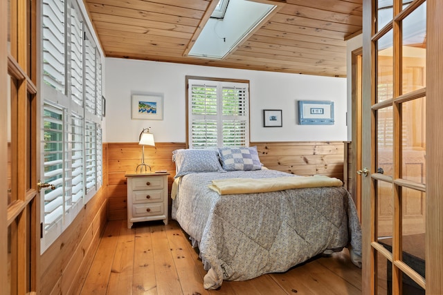 19 Fox Ln, Bremen, ME 04551 - bedroom with wood ceiling, a wainscoted wall, wood walls, light wood-style floors, and a skylight