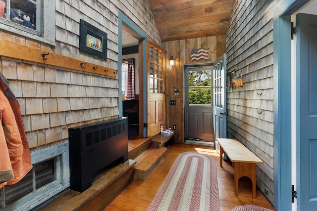 351 Mill Creek Rd, Islesboro, ME 04848 - entrance foyer with wood walls, hardwood / wood-style floors, lofted ceiling, radiator heating unit, and wood ceiling