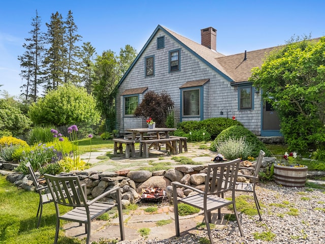 351 Mill Creek Rd, Islesboro, ME 04848 - rear view of property featuring a fire pit, a chimney, a shingled roof, and a patio