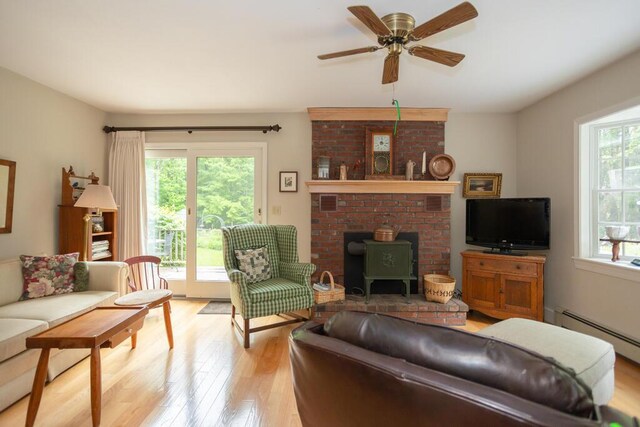 3 Fenderson Hill N, Wilton, ME 04294 - living area with light wood-type flooring, a wood stove, ceiling fan, and a baseboard radiator