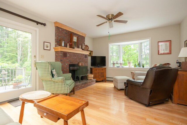 3 Fenderson Hill N, Wilton, ME 04294 - living room featuring light wood-style floors, ceiling fan, baseboard heating, and a brick fireplace