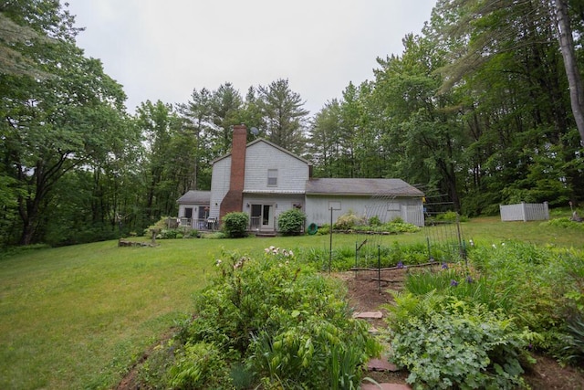 3 Fenderson Hill N, Wilton, ME 04294 - rear view of house featuring a garden, a yard, a chimney, and a deck