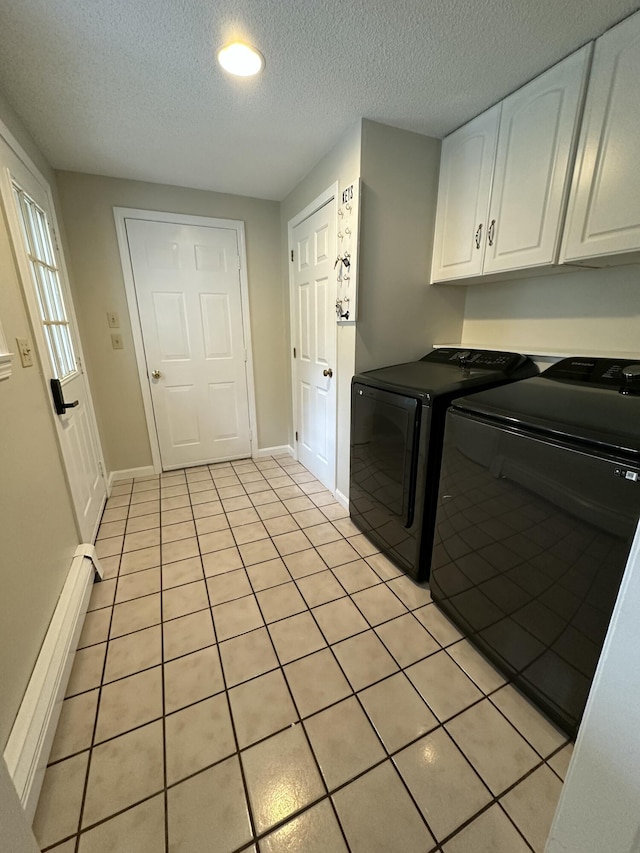 53 Pennacook Cir, Wells, ME 04090 - laundry area featuring washing machine and dryer, cabinet space, a textured ceiling, light tile patterned floors, and a baseboard heating unit
