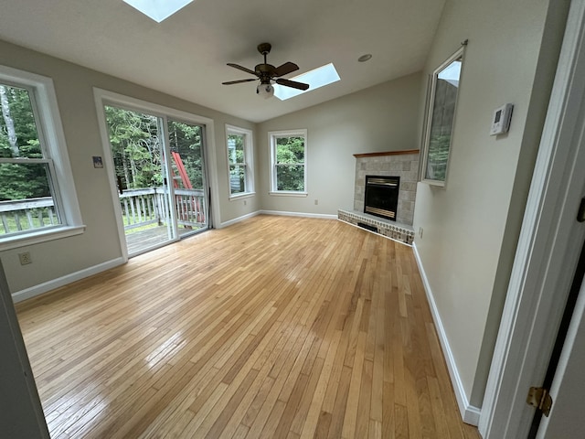 53 Pennacook Cir, Wells, ME 04090 - unfurnished living room featuring a skylight, a brick fireplace, light wood-type flooring, vaulted ceiling, and ceiling fan
