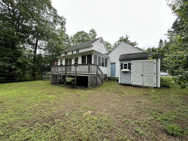53 Pennacook Cir, Wells, ME 04090 - back of property featuring a wooden deck, a lawn, a storage shed, and a shingled roof