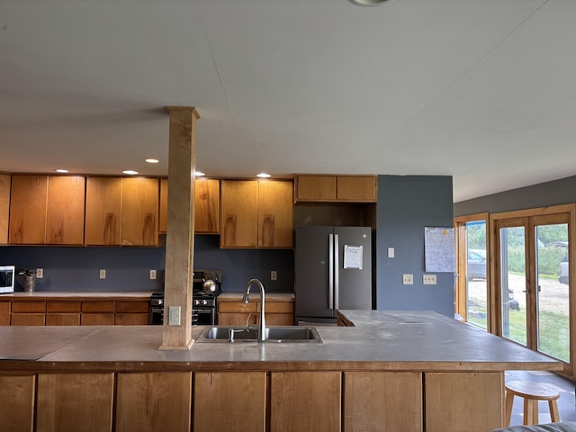 440 Temple Rd, Wilton, ME 04294 - kitchen with freestanding refrigerator, gas range oven, and brown cabinets