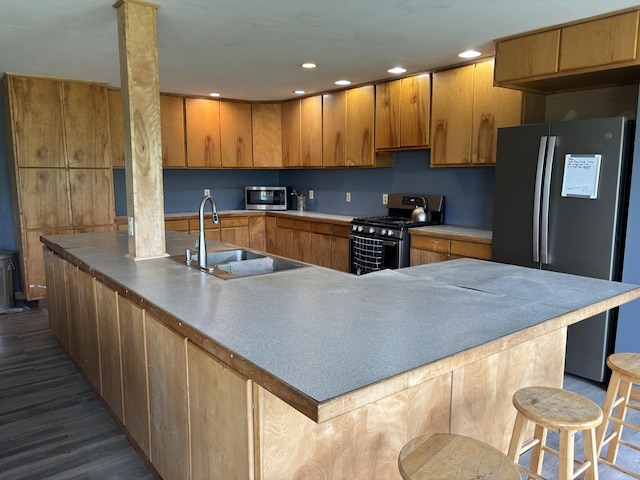 440 Temple Rd, Wilton, ME 04294 - kitchen with appliances with stainless steel finishes, dark wood finished floors, brown cabinets, a breakfast bar area, and recessed lighting
