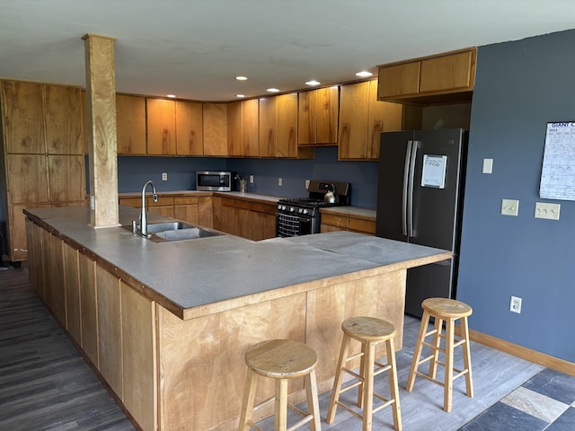 440 Temple Rd, Wilton, ME 04294 - kitchen featuring stainless steel appliances, brown cabinets, recessed lighting, and a kitchen breakfast bar