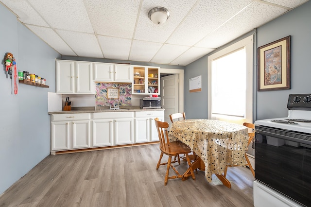 323 Cumberland St, Rumford, ME 04276 - kitchen with white electric range, a drop ceiling, open shelves, light wood-type flooring, and white cabinets