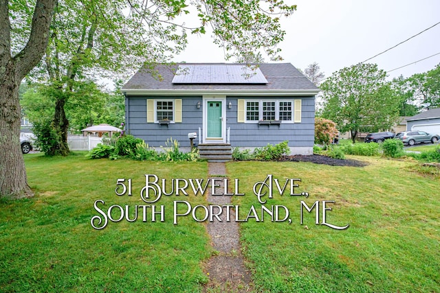 51 Burwell Ave, South Portland, ME 04106 - bungalow-style house with a front yard, roof mounted solar panels, entry steps, and a shingled roof