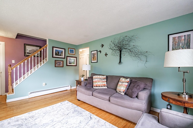 51 Burwell Ave, South Portland, ME 04106 - living room with a baseboard heating unit, wood finished floors, stairs, and a textured ceiling