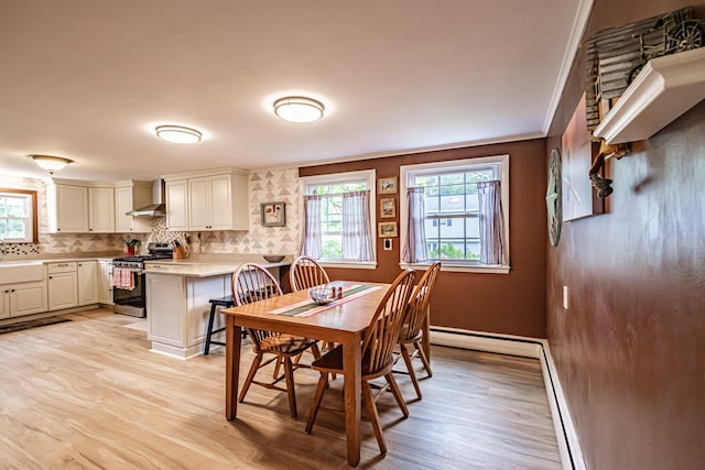 51 Burwell Ave, South Portland, ME 04106 - dining room featuring light wood-type flooring, a baseboard heating unit, and crown molding
