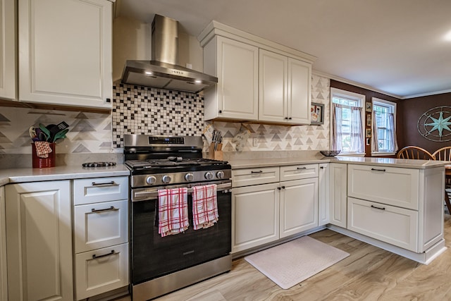 51 Burwell Ave, South Portland, ME 04106 - kitchen featuring stainless steel gas range oven, wall chimney range hood, light countertops, a peninsula, and light wood finished floors