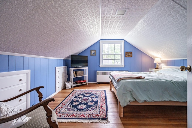 51 Burwell Ave, South Portland, ME 04106 - bedroom featuring radiator, wood finished floors, and lofted ceiling