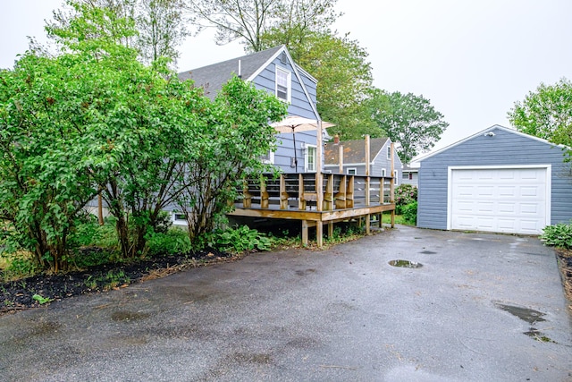 51 Burwell Ave, South Portland, ME 04106 - view of front of home with a garage, a deck, asphalt driveway, and an outbuilding