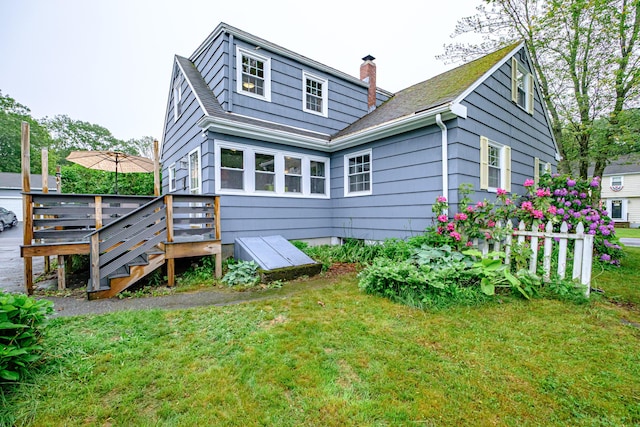 51 Burwell Ave, South Portland, ME 04106 - back of house featuring a chimney, a lawn, a deck, and a shingled roof