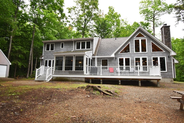 107 Shady Ln, Newport, ME 04953 - rear view of property featuring a sunroom, a chimney, a wooden deck, and roof with shingles