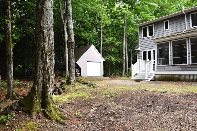 107 Shady Ln, Newport, ME 04953 - view of yard featuring an outdoor structure, a garage, dirt driveway, and a sunroom