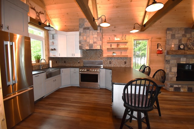 107 Shady Ln, Newport, ME 04953 - kitchen with premium appliances, open shelves, dark countertops, a peninsula, and wood ceiling