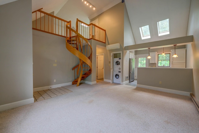 4 Cheshire Meadows Ln Unit 4, Kennebunk, ME 04043 - unfurnished living room featuring high vaulted ceiling, stacked washer and clothes dryer, a skylight, light colored carpet, and stairway