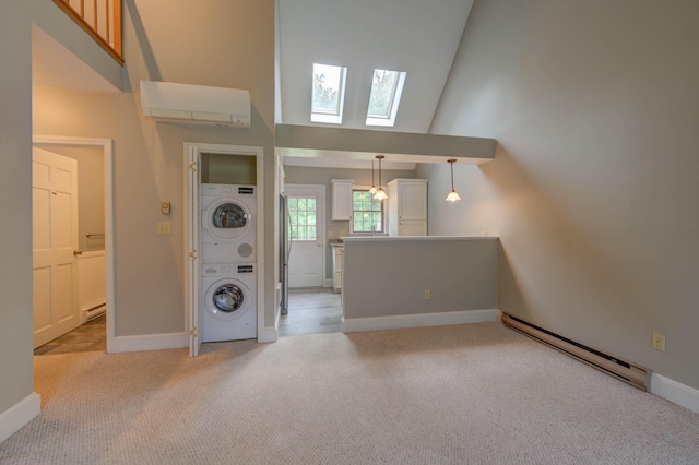 4 Cheshire Meadows Ln Unit 4, Kennebunk, ME 04043 - unfurnished living room with stacked washer / drying machine, baseboard heating, a skylight, light carpet, and high vaulted ceiling