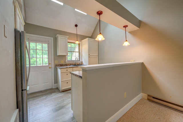 4 Cheshire Meadows Ln Unit 4, Kennebunk, ME 04043 - kitchen with freestanding refrigerator, a baseboard radiator, white cabinets, vaulted ceiling, and pendant lighting