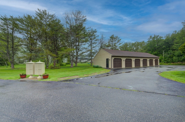 4 Cheshire Meadows Ln Unit 4, Kennebunk, ME 04043 - view of side of property featuring mail area, a lawn, an outdoor structure, and community garages