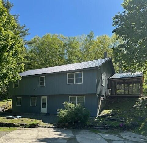 2073 Western Ave, Newburgh, ME 04444 - view of property exterior with a sunroom, a chimney, and a metal roof