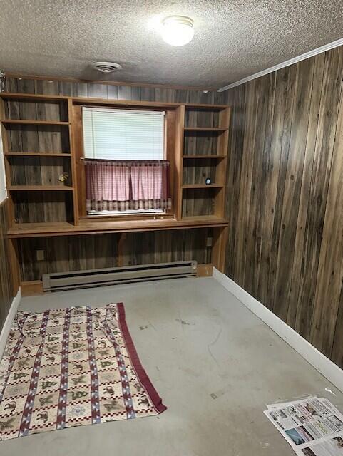2073 Western Ave, Newburgh, ME 04444 - below grade area with a baseboard radiator, wood walls, and a textured ceiling