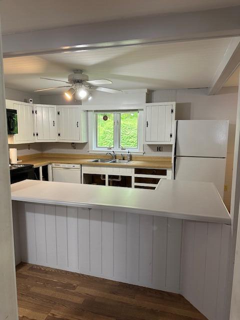 2073 Western Ave, Newburgh, ME 04444 - kitchen featuring white appliances, dark wood-style flooring, white cabinets, light countertops, and beamed ceiling